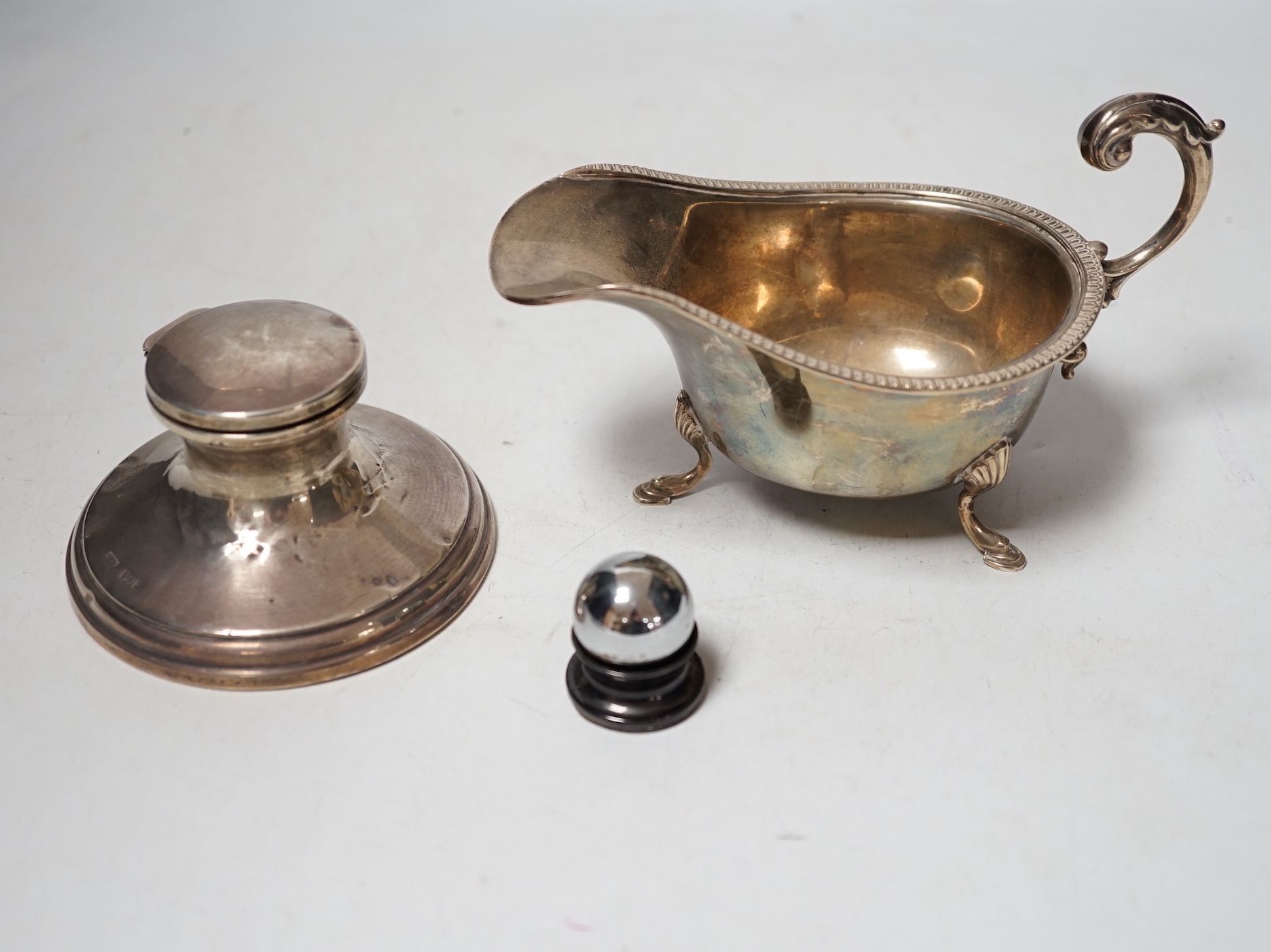A 1930's silver sauceboat a silver mounted inkwell and one other item.